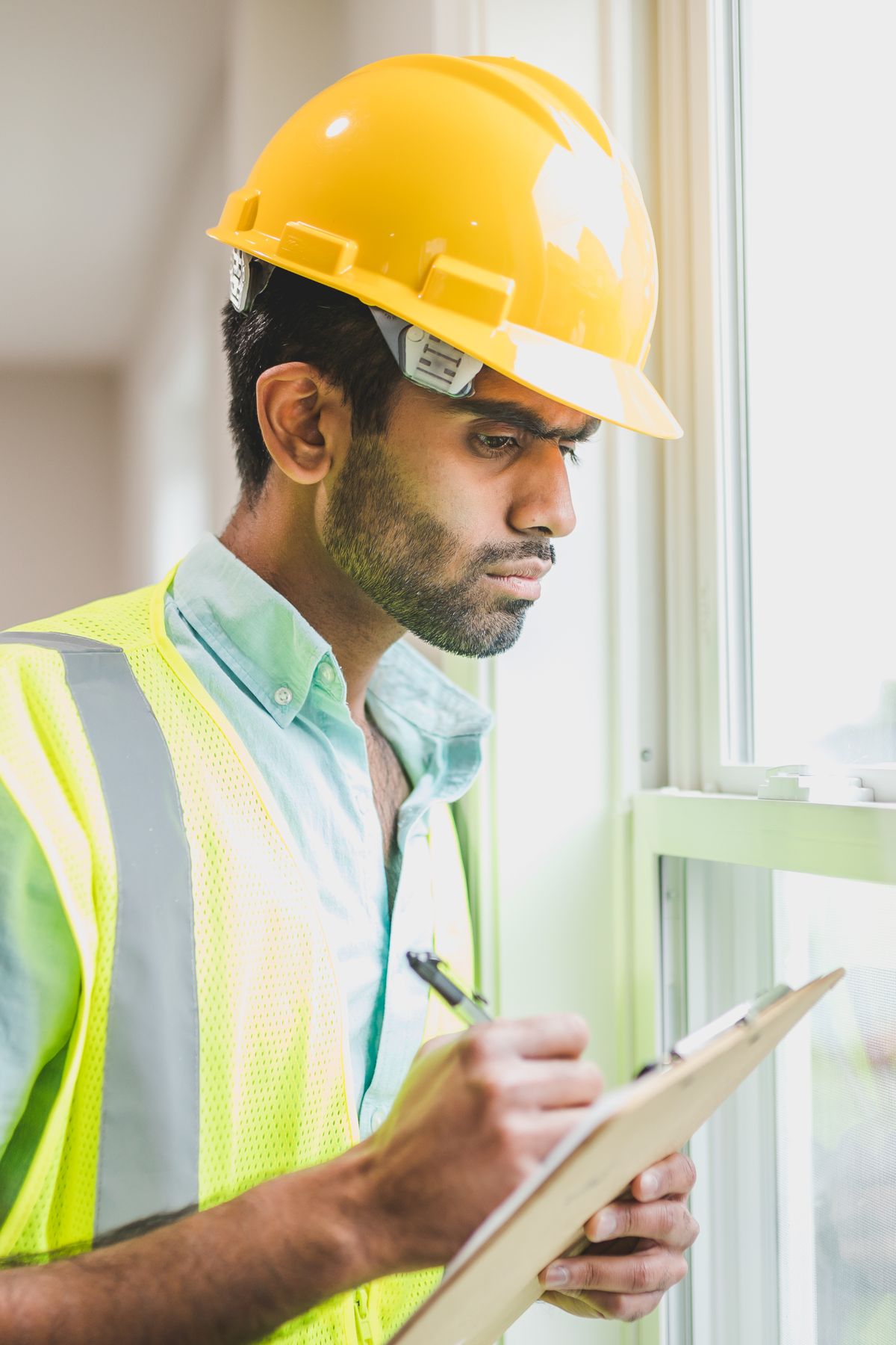 Property inspector checking a window and recording findings